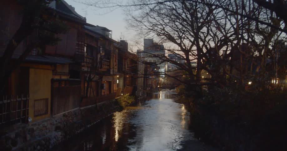 People in masks walk next to a flowing stream