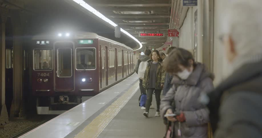 Passengers wait for the subway train arriving at the station