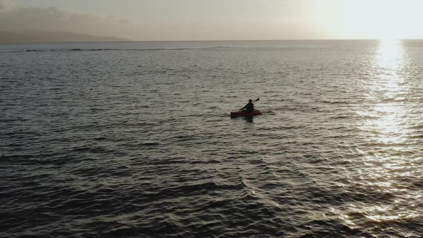 A person kayaks in an ocean