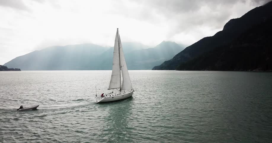 A boat sails through the water surrounded by mountains