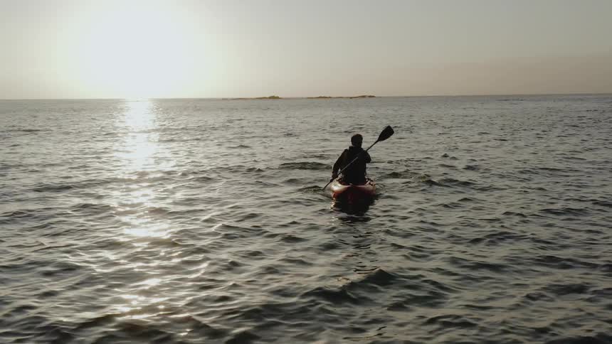 A man paddles a kayak through the water