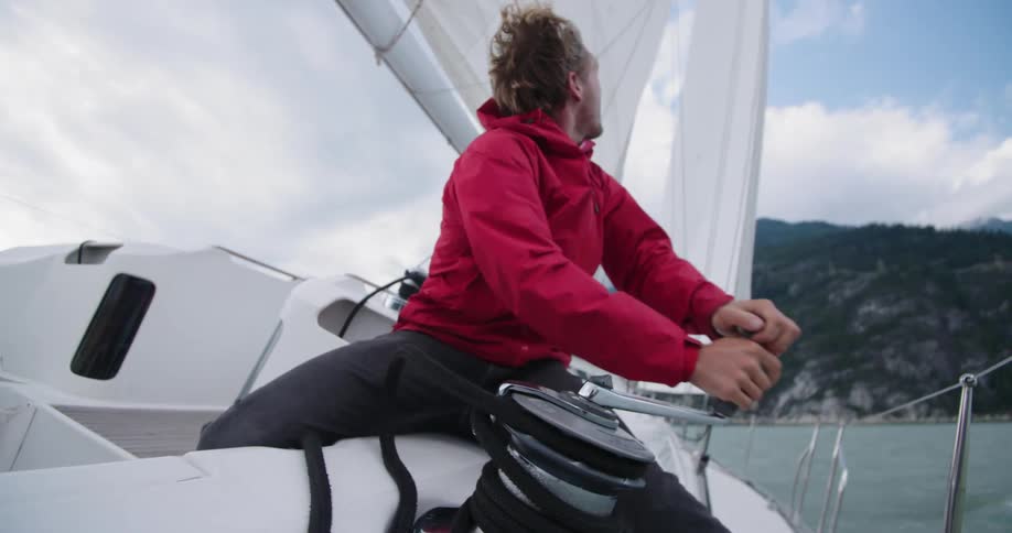 Man coils rope on sailboat