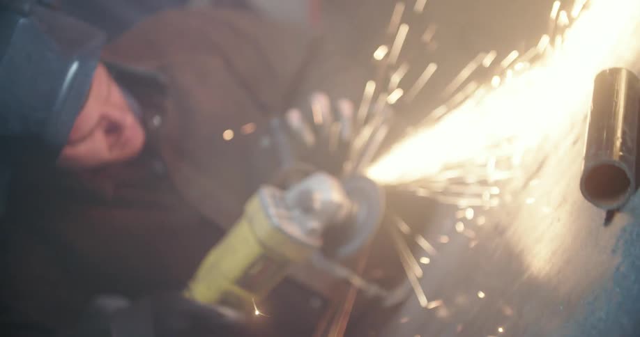 Sparks fly from a grinder as a man holds it