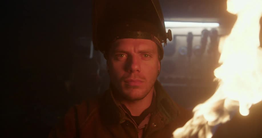 A man holds a torch closely in front of him