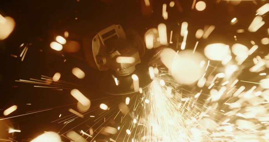 Sparks fly as a welder uses a metal grinder
