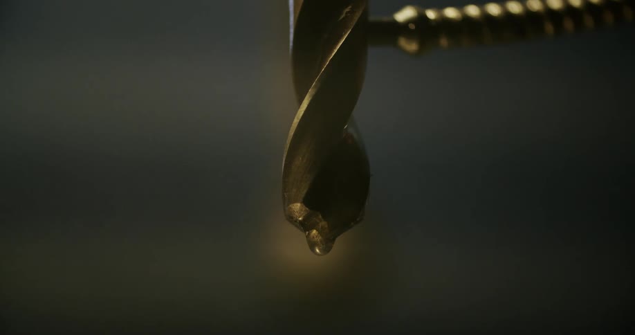 A small hose putting liquid on a drill