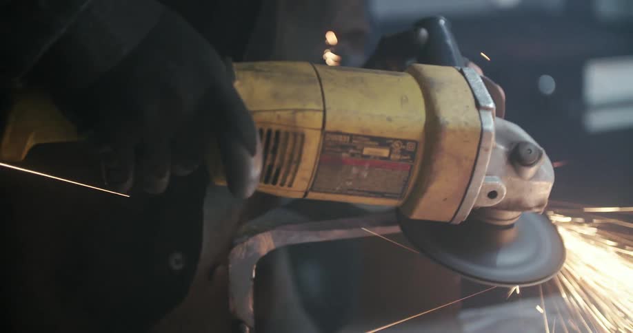A man looks down as he uses a tool