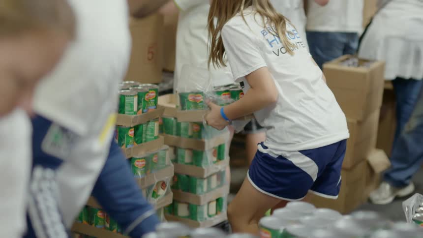 People picking up boxes of canned vegetables