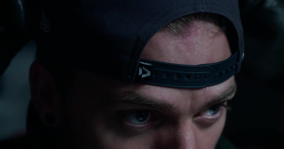 A man putting on a baseball cap backwards