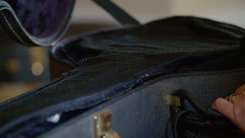 A person is taking an instrument out of a case