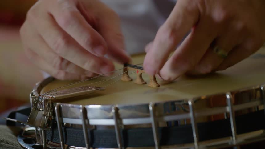 A man strings a banjo