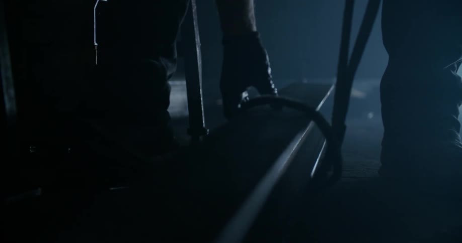 A person adjusts a strap around a metal beam