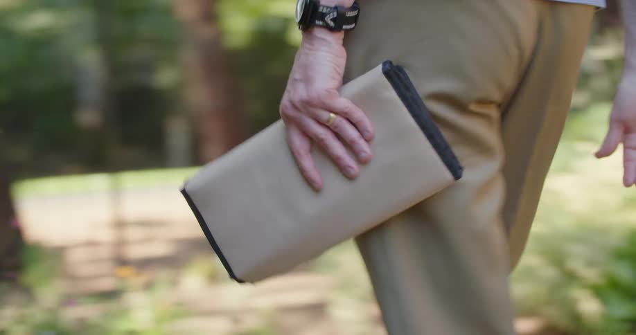 A man walks along carrying a package