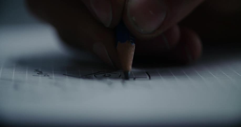 A person draws on a piece of lined paper