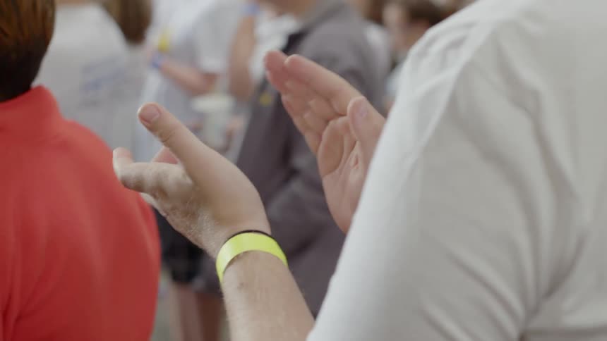 A man claps in a crowd of people