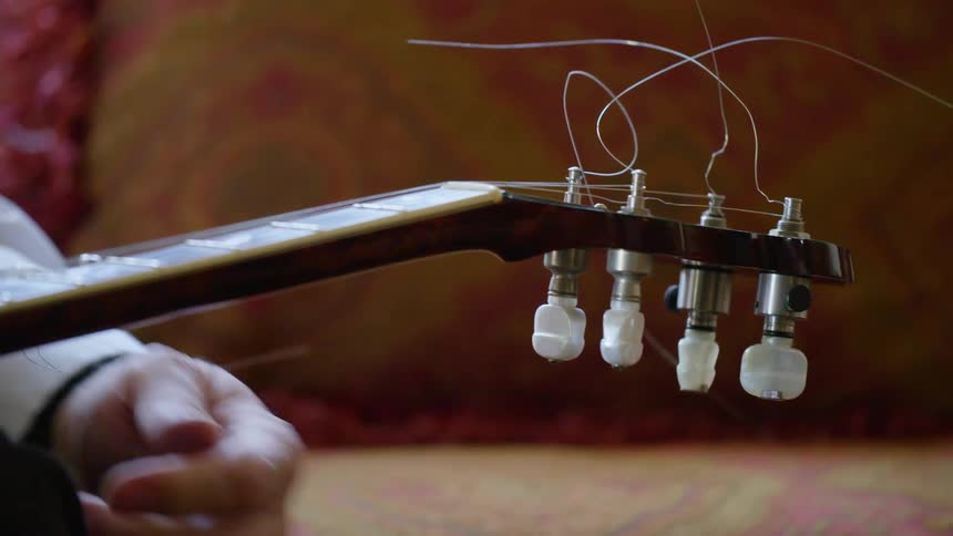 A man tunes a guitar