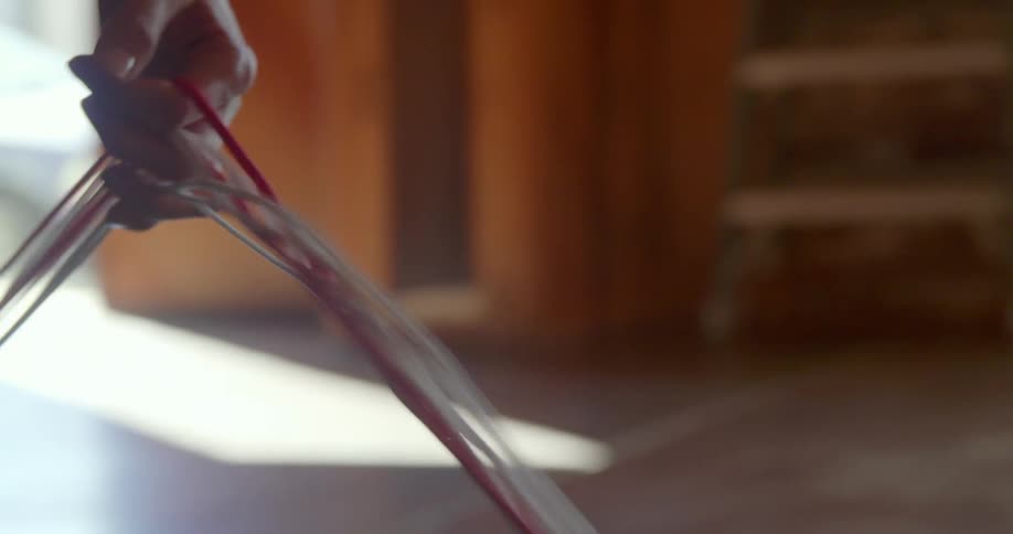 A person holds a bundle of wires in their hand and walks forwards