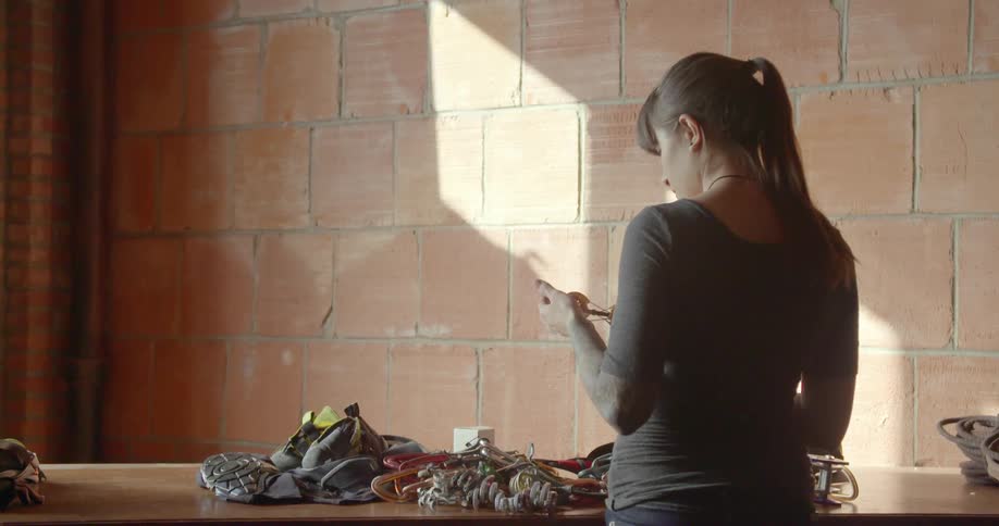 A woman examines ropes and tools