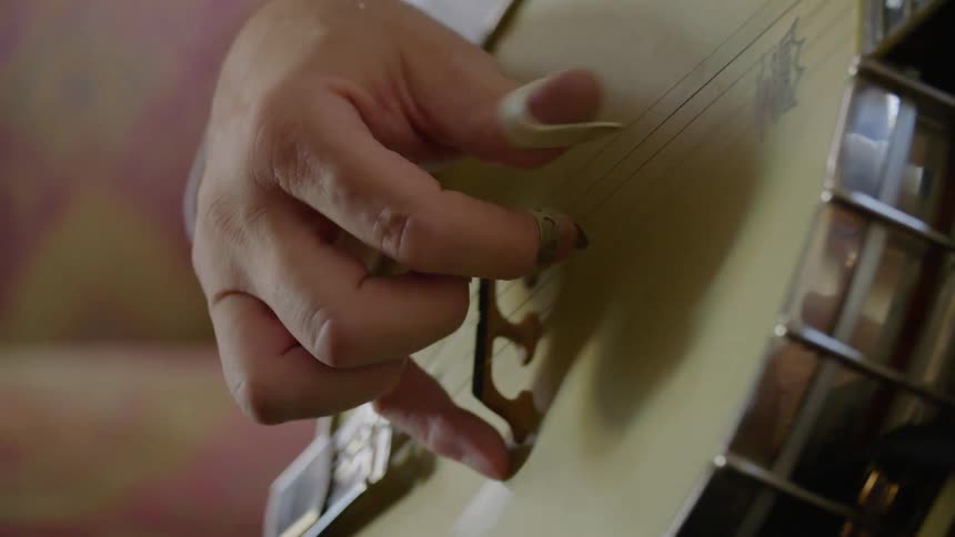 A person hand playing the banjo