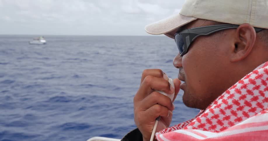 A man talks into a radio on a boat