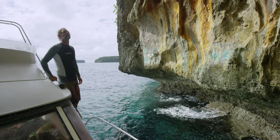 A man stands on a boat on the ocean