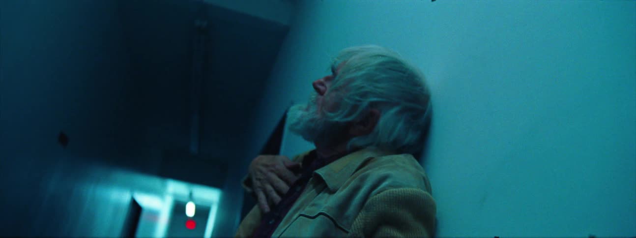 An elderly man rolls against a wall