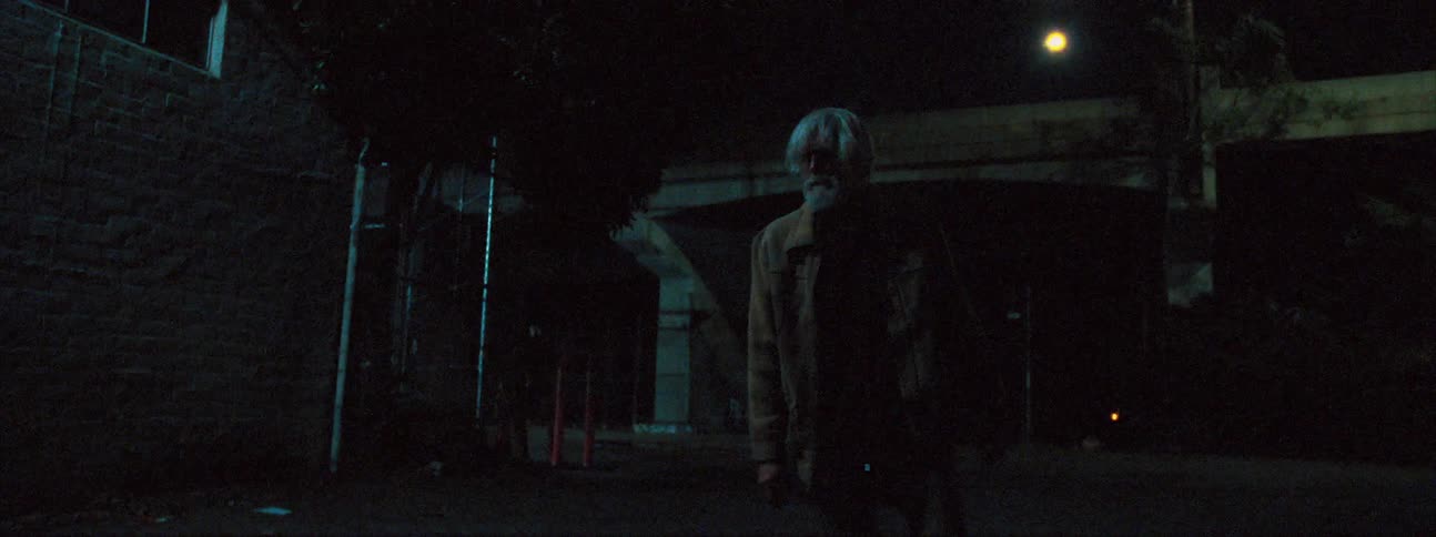 Beggar tries to walk down the street at night
