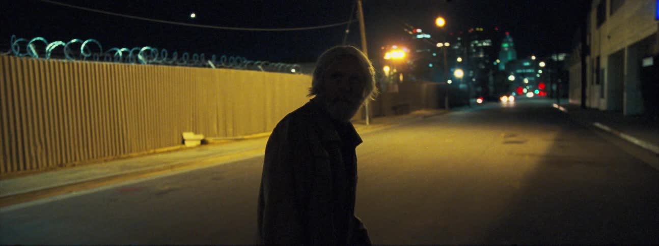 A man looking behind then running on a city street