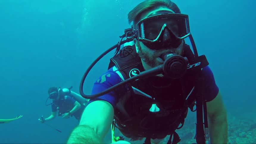 Male scuba diver exploring the ocean with friends