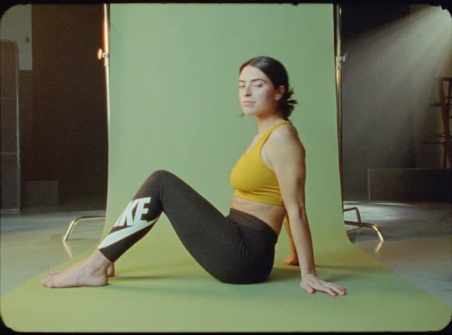 Female sitting on floor posing for a photo shoot in a studio