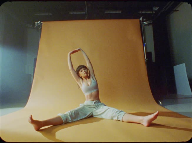 A woman is sitting on the stage stretching