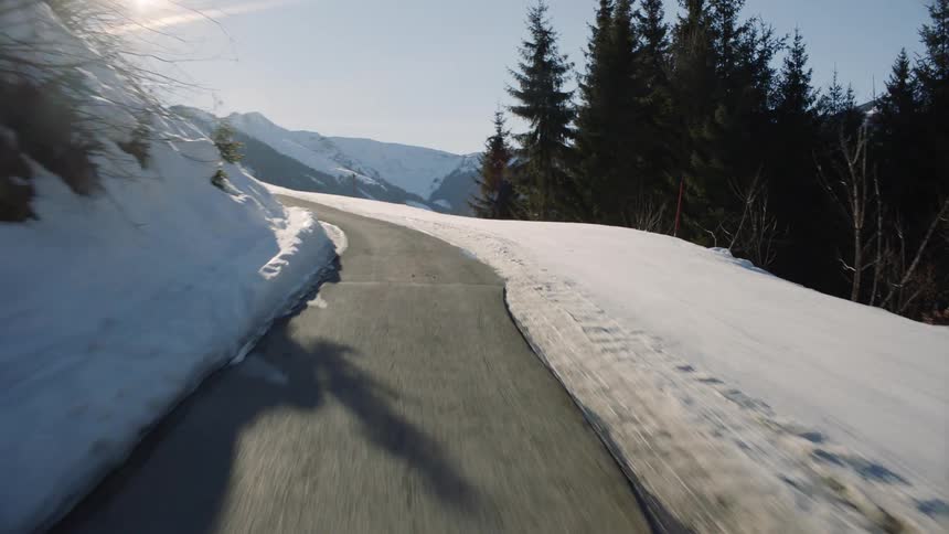 Vehicle drives along the winding narrow road in the snowy mountains