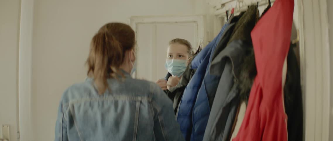 Woman looking in the mirror wears a face mask and gets out of the room