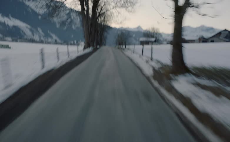 Driving fast on rural road through snow covered landscape