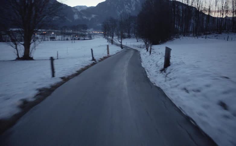 Vehicle drives along the road in the snowy countryside