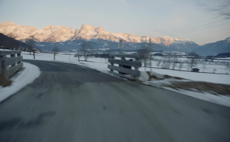 A road through a snowy countryside during the day