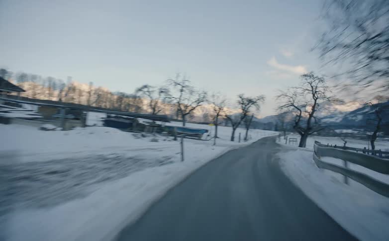 Driving fast on country road through snow covered landscape