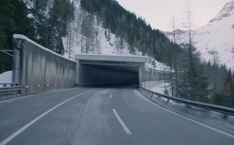 A vehicle drives through a mountainside tunnel