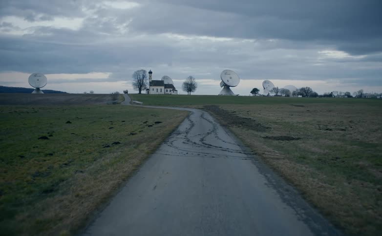 Road leads to building surrounded by large satellite dishes