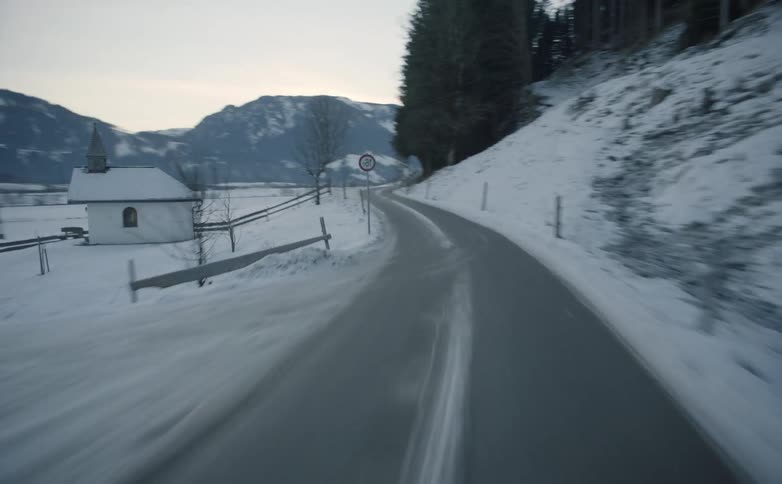 Vehicle drives along the road in the snowy countryside