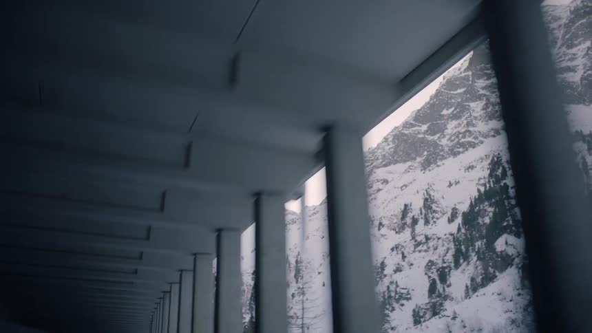 A car drives alongside a snow covered mountain