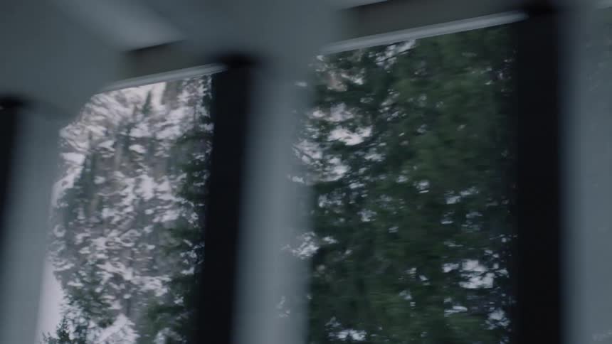 A tunnel with pillars next to a mountain with trees