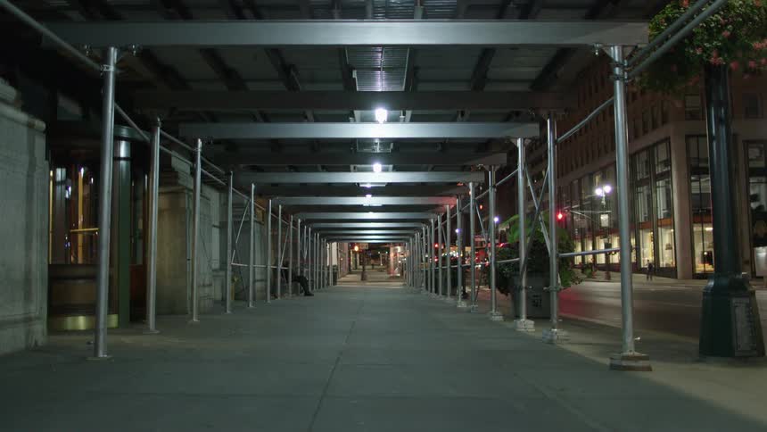 A quiet city street with few cars and people about