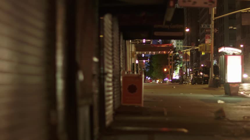 A gritty city sidewalk is lit up by flashing police lights