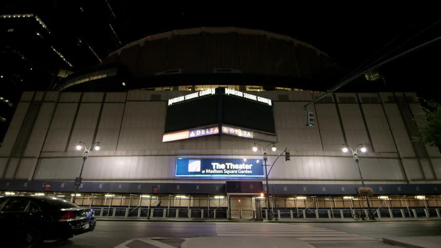 The facade of a theater in a city at night