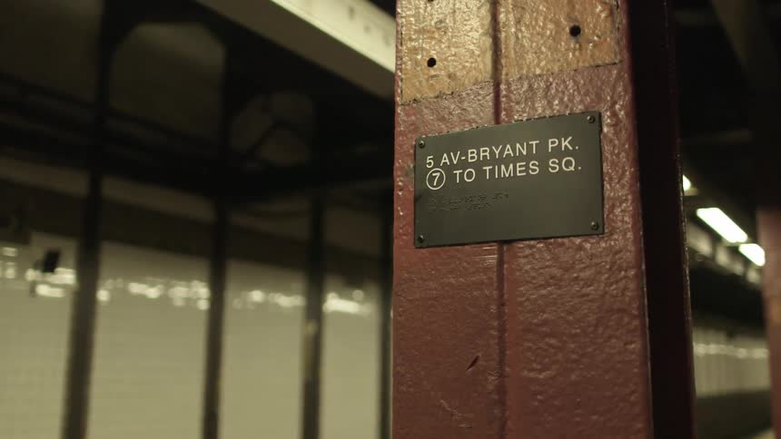 A sign on a post in a train station