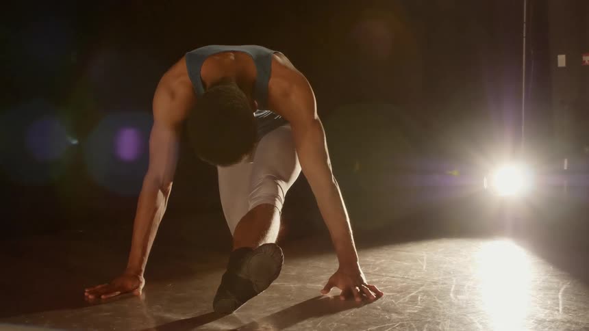 A man stretches on stage