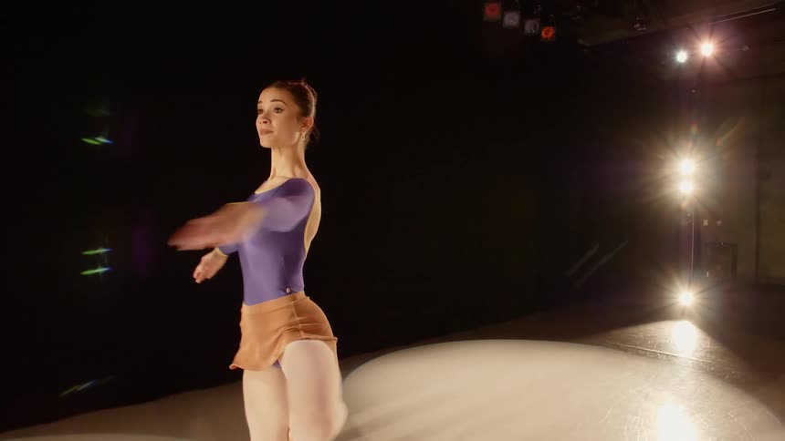 Ballet dancer doing pique turns across stage under the spotlights