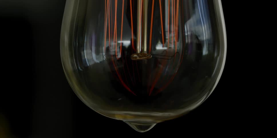 A glass bulb with wires inside lights up