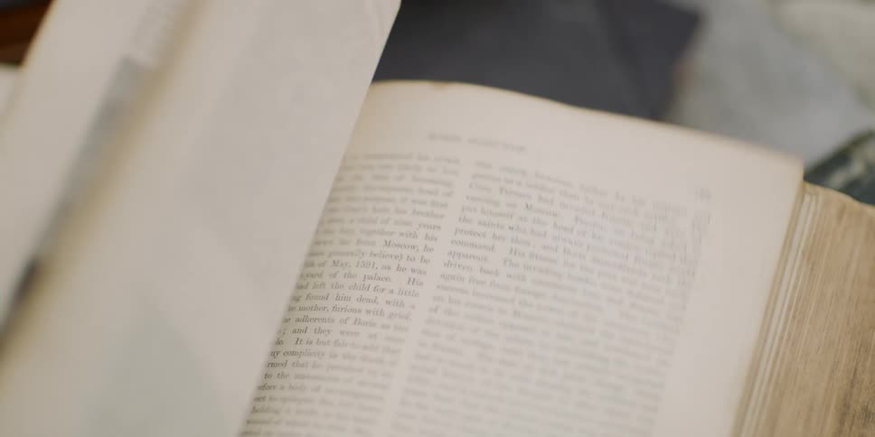 The pages of a thick illustrated book flipping in slow motion
